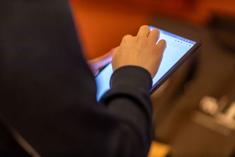Person browsing on a tablet held in one hand